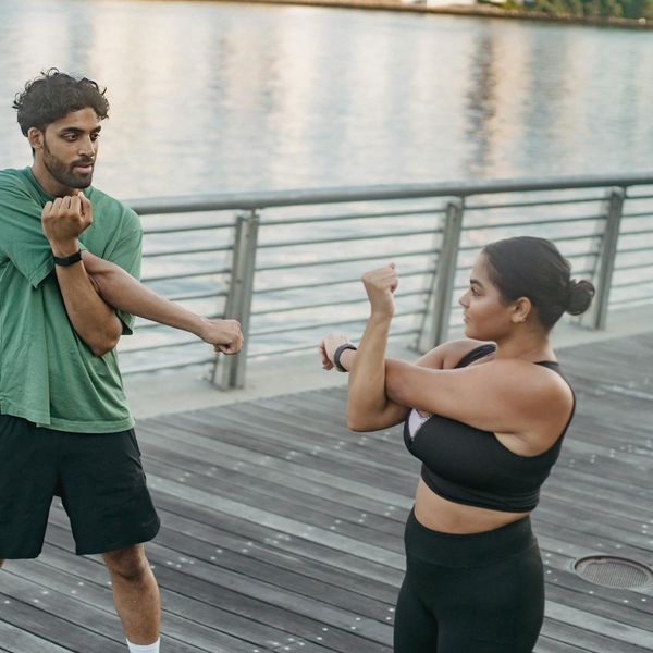 Man stretching outdoors at sunrise, looking refreshed and energetic.